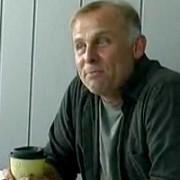 Blond man with a disposable coffee cup